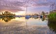 Christchurch Quay docked with sailboats and Priory in the distance.