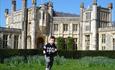 Little boy running on grass in front of castle