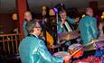 Male band with green shiny jackets and percussion instruments