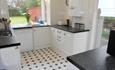 White, clean kitchen with lots of light coming through the windows