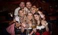 A group celebrating Oktoberfest with Steins in hand at the bic