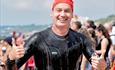 Man with swimming gear on holding two thumbs up