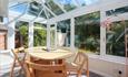 Bright conservatory with dining table and chairs