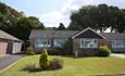 Exterior view of modern bungalow with green grass and blue sky