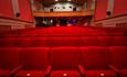 Inside the screen room facing away from the screen with red seating