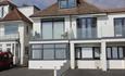 Modern house with glass balcony and car park area