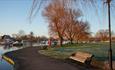 A sitting bench on the path that curves along the quay.