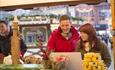 Couple browsing the festive gifts at one of Bournemouths Christmas market stalls